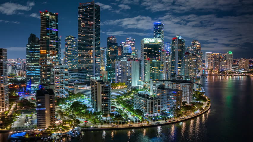Experience a stunning hyperlapse of vibrant Downtown Miami, highlighting the lively Brickell Key at night, showcasing its impressive skyline and beautiful waterfront that capture the citys essence