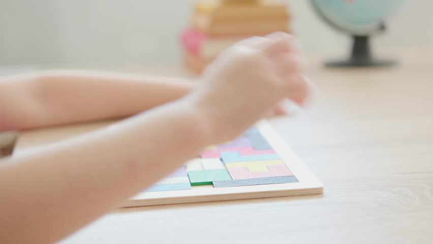 female child hands manipulate colorful wooden geometric shapes intellectual puzzle, intelligence quotient, fun playing with wooden blocks, development of fine motor skills