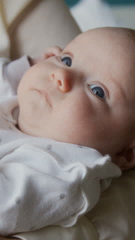 Unrecognizable granny helping with newborn baby, rocking it arms while tired mother taking nap in maternity hospital room