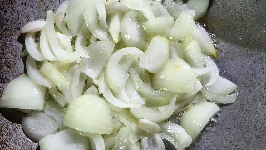 Frying chopped onion in pan, in door Chiangmai Thailand.