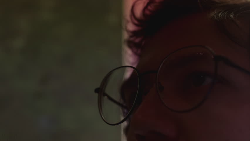 Reflection of bitcoin in glass glasses. A man looks at the cryptocurrency logo, makes an Investment in the blockchain. The male trader. Broker trading online. Altcoins crypto currency trading