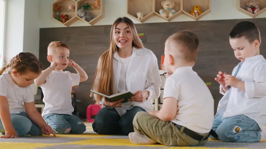 With book, sitting on the floor. Children in kindergarten with their teacher.
