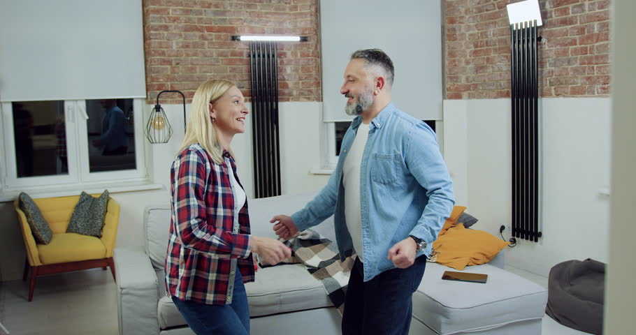 Family couple which having fun together when dancing twist in living-room during family evening time