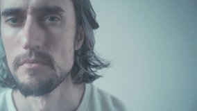 Close-Up of a Serious and Contemplative Young Man with Large Eyes and Defined Jawline, Captured in Soft, Muted Tones and Gentle Lighting, Intimate Shot of Melancholic Expressions - Powered by Shutterstock - Get 15% off with code: PIKWIZARD15