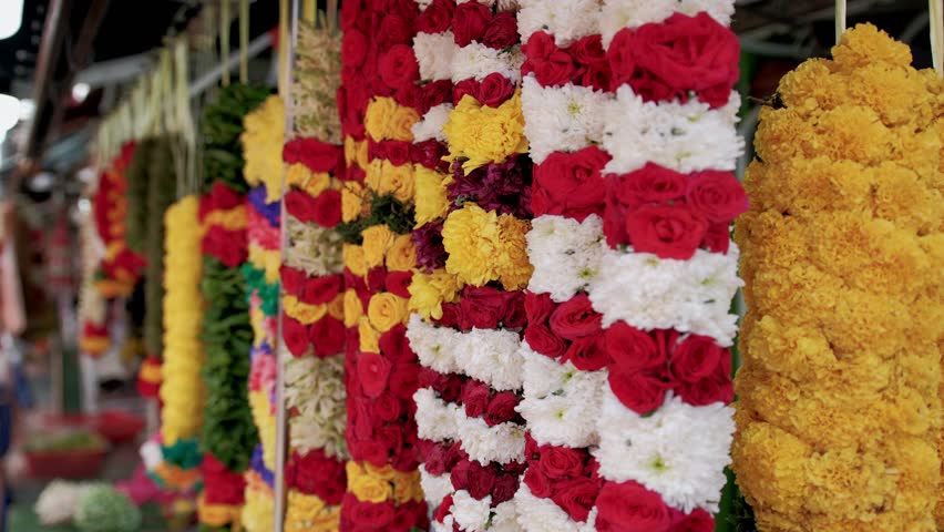 Vibrant flower garlands, a traditional Indian offering, hang in a singapore street market, creating a colorful display