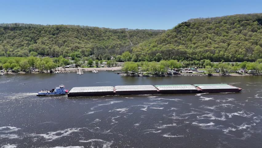 Located along the Mississippi River between Minnesota and Wisconsin's Driftless area, the Thomas Erickson Towboat and barges slowly move north.