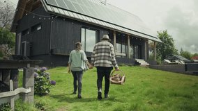 Farmers walking hand in hand towards their modern, sustainable farmhouse equipped with solar panels on the roof - Powered by Shutterstock - Get 15% off with code: PIKWIZARD15