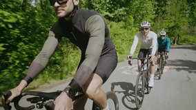 Male bicyclist with smartwatch rides bicycle leading teammates on country road. Professional athletes conduct training race on bikes at summer countryside - Powered by Shutterstock - Get 15% off with code: PIKWIZARD15