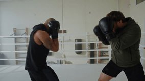 Confident man athlete with prosthetic leg attacks black partner at sparring in gym. Sportsman with disability fights African American guy in boxing ring - Powered by Shutterstock - Get 15% off with code: PIKWIZARD15