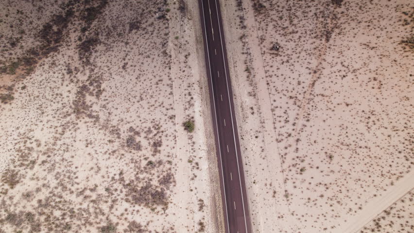 Aerial view of an empty stretch of desert highway near Big Bend in west Texas tilts up to horizon