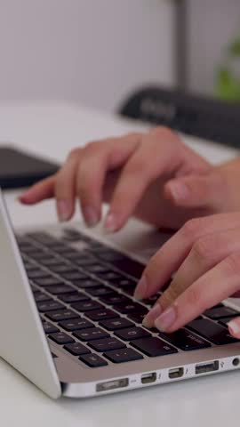 Vertical HD video. Close up female hands typing on computer sitting in the office. Young woman working on laptop at home while eating healthy salad for dinner at home. Technology lifestyle concept