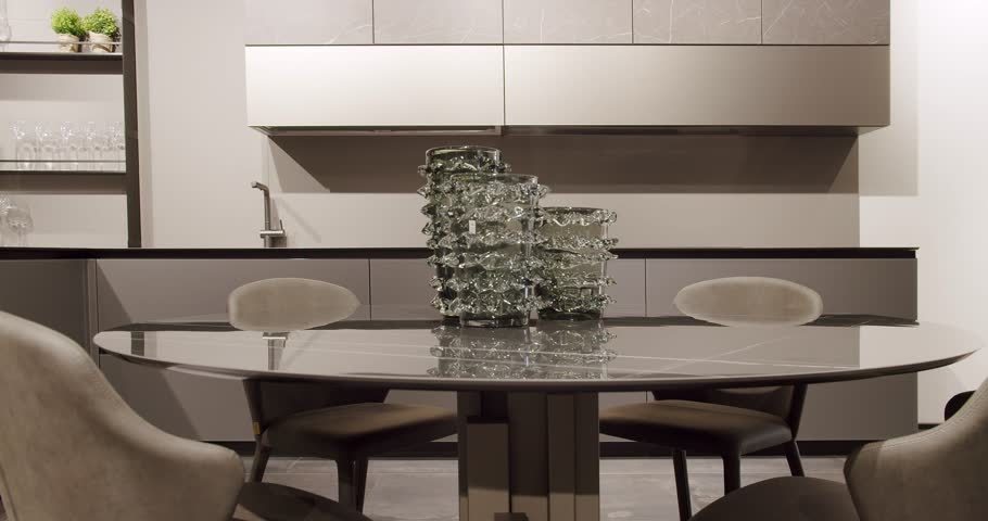Leather modern gray chair in kitchen room and dining table. Modern Minimalist Home. Modern gray and white kitchen room furniture with marble table. Elegant and Comfortable Home at Dining room.
