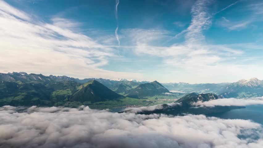 Scenic mountain landscape above clouds with lake and blue sky