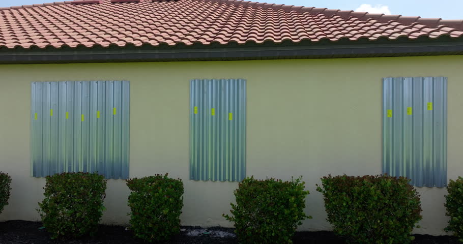 Storm shutters mounted on Florida house windows for hurricane protection. Preparing for natural disaster