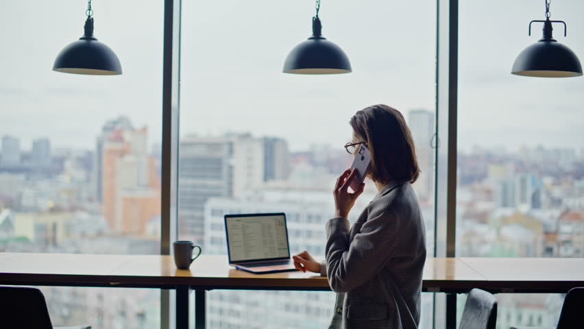 Successful manager have telephone conversation with partners clients at panoramic window closeup. Formal suit businesswoman concluding business deal on mobile phone call. Busy lawyer sitting counter