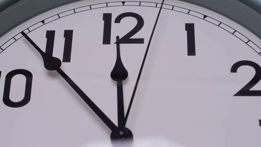 Detailed close-up of a wall clock showing the time at exactly 12:00 Symbolizing a new beginning countdown or deadline moment, themes of transition punctuality and time awareness.