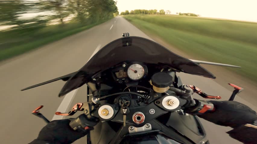 Experience the freedom of an empty road at sunset, captured from Gopro POV as a motorcycle cruises through a peaceful road. The golden hour light filters through the trees.