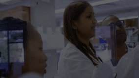 Laboratory team ending data discussion and activating swirling cybersecurity HUD over glass panel. Science, innovation, collaboration, technology, security, research, visualization - Powered by Shutterstock - Get 15% off with code: PIKWIZARD15