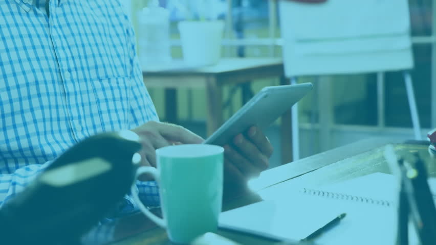 Mid adult male tapping tablet showing chat bubble overlay while sipping coffee for business chat. Professional, workspace, collaboration, modern, technology, communication, relaxation
