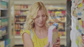 Female shopper picking up box from store shelf and scanning label with data rings. Retail, commerce, technology, innovation, consumer, digital, lifestyle - Powered by Shutterstock - Get 15% off with code: PIKWIZARD15