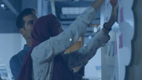 Colleagues adding sticky notes and swiping smartphone overlaying data icons for business analytics. Collaboration, teamwork, data visualization, digital interface, brainstorming, office environment, - Powered by Shutterstock - Get 15% off with code: PIKWIZARD15