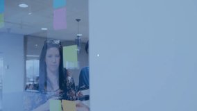 Employees studying sticky notes in business meeting sparking overlay of globe and chart icons. Collaboration, innovation, teamwork, data visualization, digital connectivity, modern workspace, - Powered by Shutterstock - Get 15% off with code: PIKWIZARD15