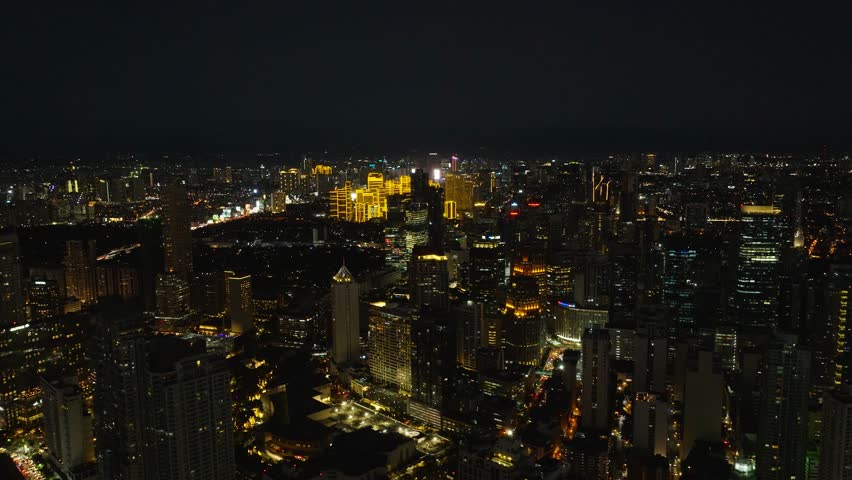 Manila with night skyline highlights its bustling streets, illuminated buildings, and dynamic urban lifestyle. Metro Manila, Philippines.