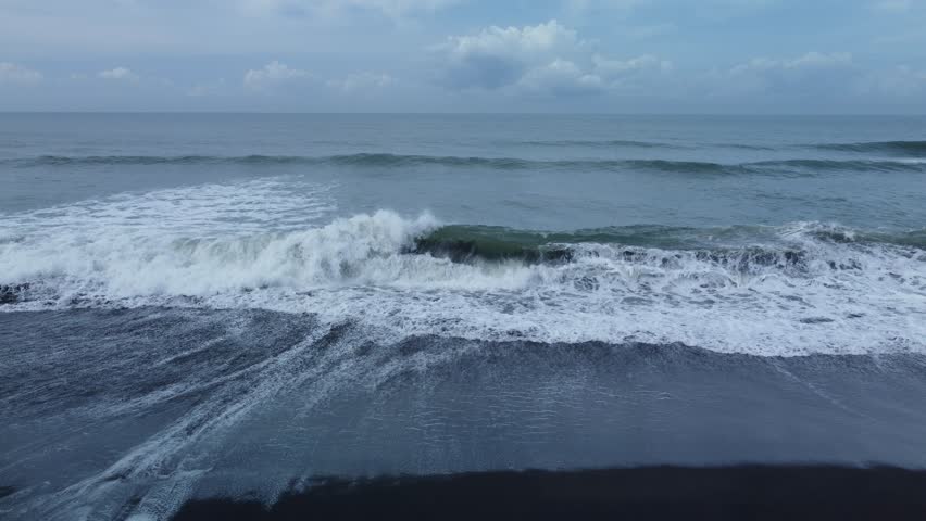 Beautiful texture of big power dark ocean waves with white wash. Aerial top view footage of fabulous sea tide on a stormy day. Drone filming breaking surf with foam in Indian ocean.