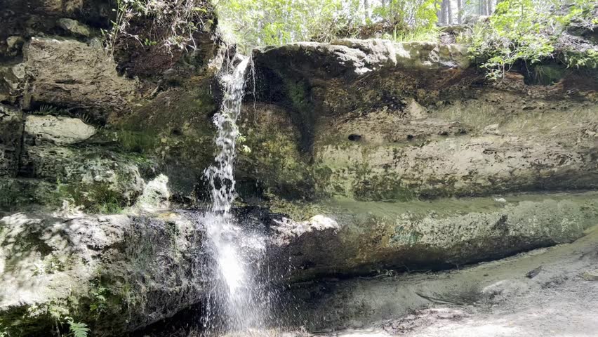 Handheld half speed clip of a small waterfall in South Carolina in dappled sunlight