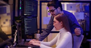 Two Asian software engineers collaborate at night in modern office, writing machine learning algorithms and debugging artificial intelligence code on multiple monitors in AI tech development workflow. - Powered by Shutterstock - Get 15% off with code: PIKWIZARD15