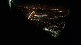 View from airplane window showing glowing city lights at night - Powered by Shutterstock - Get 15% off with code: PIKWIZARD15