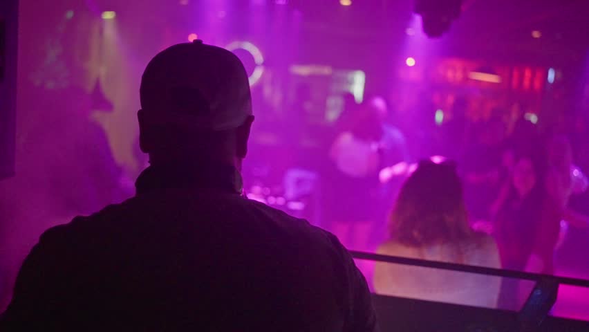 An Exciting and Vibrant Nightclub Scene DJ Skillfully Performing Live for an Enthusiastic Audience