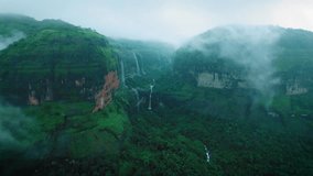 4K Aerial view of Dramatic monsoon clouds on Sahyadri hills. Devkund waterfall as seen from Savlya ghat view point. Rainy days landscape in Maharashtra, India. Waterfall flowing in mountain after rain - Powered by Shutterstock - Get 15% off with code: PIKWIZARD15