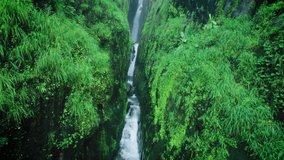 4K Aerial shot of Saatsada waterfall flowing in narrow valley of Sahyadri Hills in Maharashtra, India. Waterfall flowing between two mountain creek during monsoon. Scenic nature view. - Powered by Shutterstock - Get 15% off with code: PIKWIZARD15