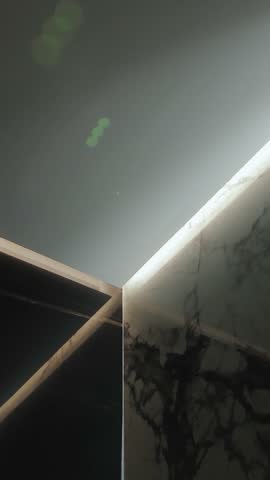 Marble wall in the bathroom with lighting. Modern design and beautiful textures in architecture and art. Vertical video