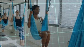 Two classmates gripping light blue aerial yoga hammocks, hooking legs and inverting for fitness. Flexibility, wellness, mindfulness, strength, balance, sporty, modern - Powered by Shutterstock - Get 15% off with code: PIKWIZARD15
