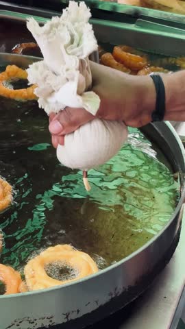 Funnel Cake making process, with human's hands and popular sweet of north America and India.