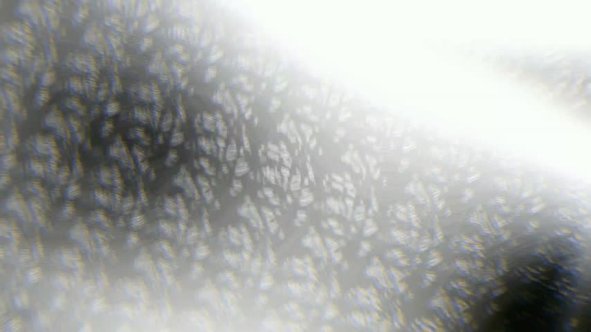 Abstract footage resembling a warped, kaleidoscopic tunnel with crystalline and liquid textures. Zoom, chromatic aberration, and distort effects create a vortex of swirling light and fragmented forms.