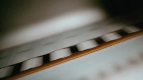 A close-up view of a vintage movie projector film gate showing a film reel moving smoothly through the classic mechanical system - Powered by Shutterstock - Get 15% off with code: PIKWIZARD15