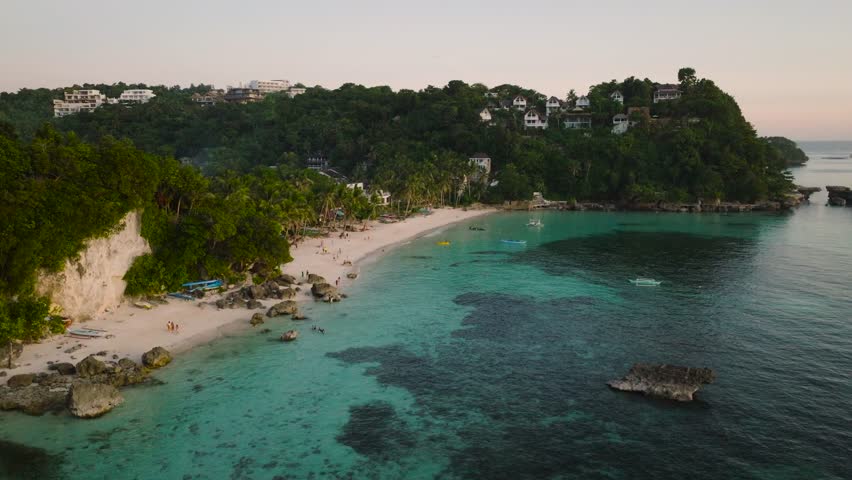 Serene tropical waters dotted with boats and surrounded by a vibrant coastline. Boracay Island, Philippines.