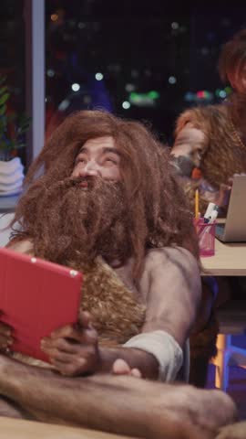 Couple of primeval savages working in modern office workspace doing project together using digital tablet technology process learning digital devices.