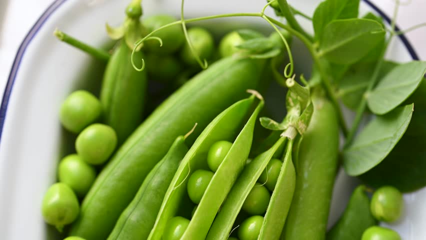 Fresh green peas in a white plate, healthy snack
