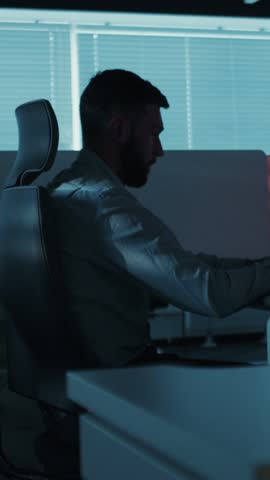 Side portrait of young bearded male businessman software developer it programmer boss night work hardworking in office concept creative technical process learning thinking resolve issue problem using