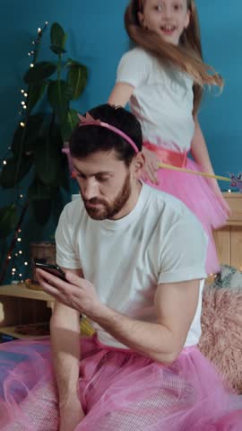 A man and a girl in matching pink tutus share a joyful moment