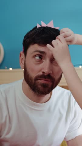 A girl crowns a bearded man, filling the air with joy and laughter