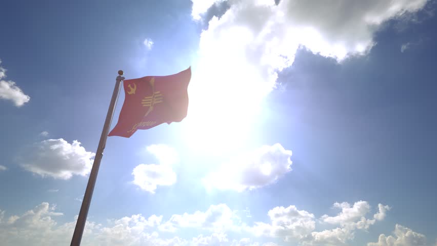 Albuquerque Flag (New Mexico, USA) waving on a Flagpole from a Moving Angle in front of a blue sky with clouds