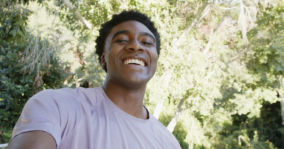 Pressing record African American man smiling and panning from bedroom into patio touring garden. Casual, outdoor, lifestyle, serenity, nature, tranquility, documentary