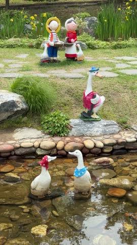 A beautiful garden with duck and doll sculptures