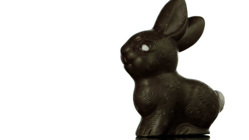 Letters spelling out easter falling and bouncing beside chocolate bunny in slow motion