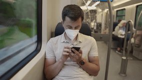 A man in a protective face mask uses his smartphone while traveling on the S-Bahn in Munich, Germany. The image captures pandemic-era public transport and digital isolation - Powered by Shutterstock - Get 15% off with code: PIKWIZARD15
